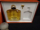a small bottle of perfume in a box with a small figurine