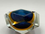 an image of a blue and yellow glass object on a white surface