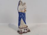 une petite figurine représentant une femme tenant un bébé dans ses bras