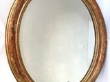 une image d'un miroir encadré d'or accroché à un mur