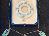 an open box with a necklace and two charms in it