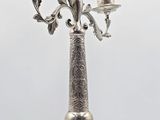 a silver candelab with three candles on it