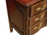 a small wooden chest of drawers with gold decorations on it