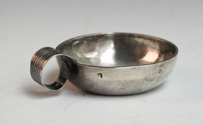 un bol en argent orné d'un anneau, posé sur une surface blanche