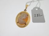 un gros plan d'un collier plaqué or orné d'une image représentant une femme