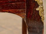 a close up of a wooden chair with gold decorations on it