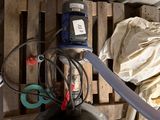 un réservoir muni d'un tuyau, placé à côté d'une palette en bois