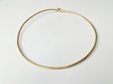 a close up of a gold necklace on a white surface