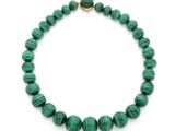 un collier vert avec un fermoir doré sur fond blanc