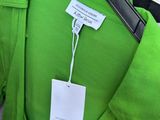 a green shirt with a tag on it and a pair of shoes