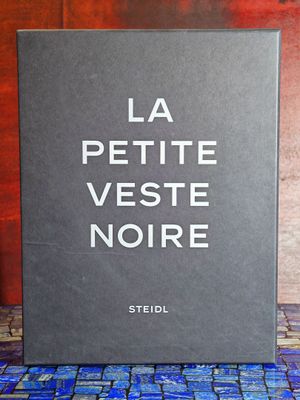 un livre posé sur une table, à côté d'un vase