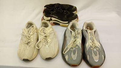 trois paires de chaussures de tennis et une boîte à chaussures posées sur une table