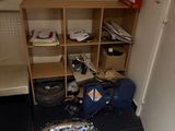 a small room with a book shelf and a bag on the floor