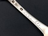 two spoons that are sitting on a black table