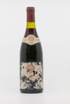 une vieille bouteille de vin posée sur une surface blanche