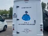 une camionnette blanche avec l'image d'un jockey à l'arrière