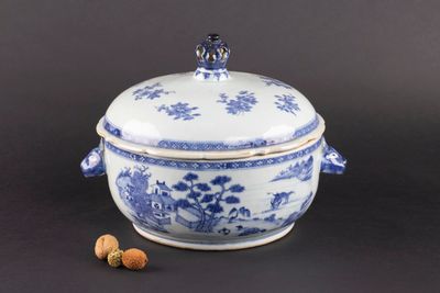 un vieux bol bleu et blanc avec un couvercle, posé à côté des noix