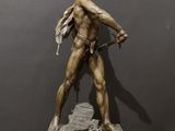 a bronze statue of a man holding a sword on a wooden base