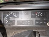 a close up of a car dashboard with a speedometer and a steering wheel