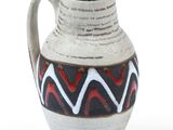 a white vase with a black and red design on it