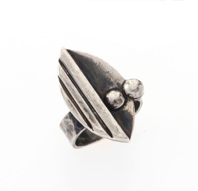 gros plan d'une bague en argent sur une surface blanche
