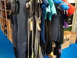 Plusieurs combinaisons sont suspendues à un portant dans un magasin