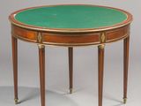an oval table with a green top and gold trim