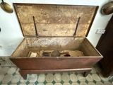 an old wooden chest with a metal lid on a tiled floor