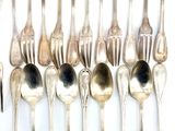 a lot of silver spoons and forks on the table