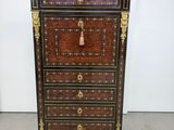 une commode noire et dorée ornée d'un pompon sur le dessus