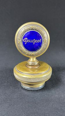 a close up of a small blue and gold object on a black surface