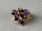 une image représentant une bague en or sertie d'améthyste et de grenats