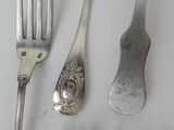 a fork, spoon, and spoon rest on a table