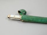 a green and white pen sitting on top of a table