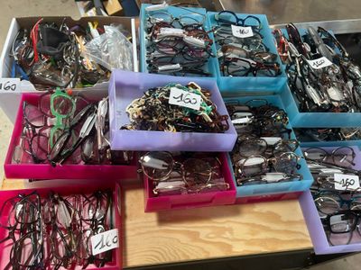 many different types of glasses in the bins on the table