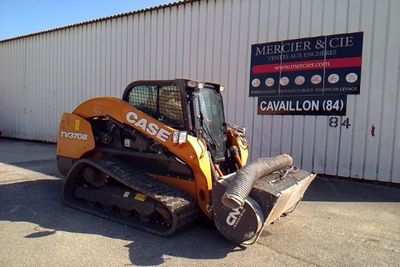 a picture of a small orange ski - door parked in front of a building