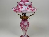 une lampe rose et blanche posée sur une table blanche