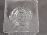 a glass ashtray on a table with a gray background