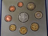 six different coins in a silver box on a table