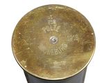 a metal container with a brass lid on a white surface