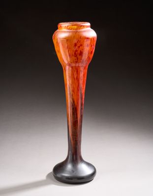 an orange vase sitting on top of a white table next to a black wall