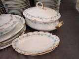 many plates and bowls that are stacked on a table