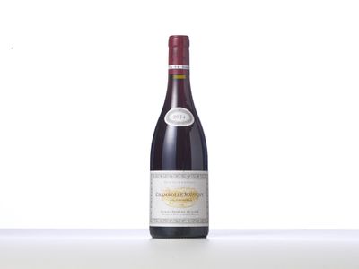 a bottle of red wine sitting on top of a white table