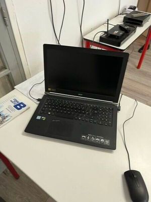 un ordinateur portable posé sur un bureau avec une souris