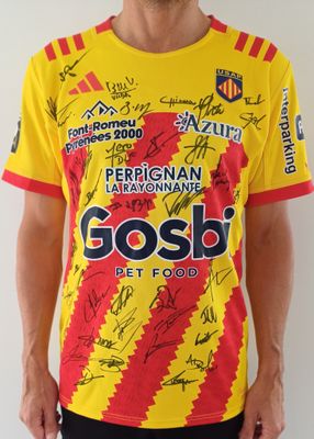 Cet homme porte un t-shirt jaune et rouge sur lequel figurent de nombreux autographes.
