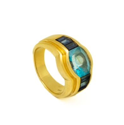 a close up of a gold ring with a blue stone