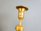 une bougie dorée posée sur une table