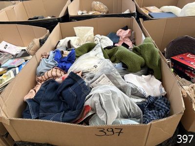 une boîte en carton remplie de vêtements et de jouets, posée par terre