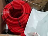 a red hose sitting inside of a box next to other boxes