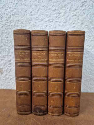 four old books sitting on top of a wooden table